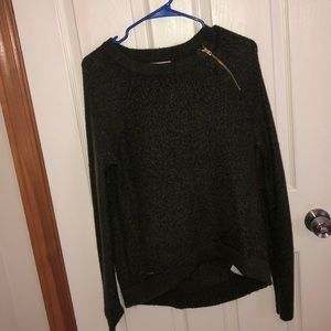 A green sweater with a gold zipper
